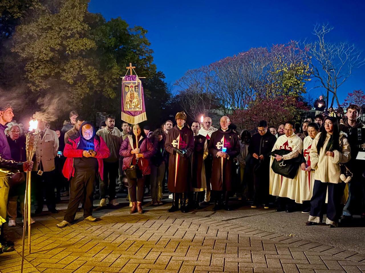 Hérauts de l'Évangile et fidèles en prière aux flambeaux, avec une bannière, sur le parvis de l'Oratoire Saint-Joseph